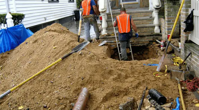 Contractors performing foundation protection and exterior drainage excavation near residential home steps in Albany, NY